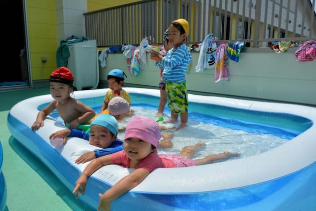二歳児の園児がミニプールに入っている写真